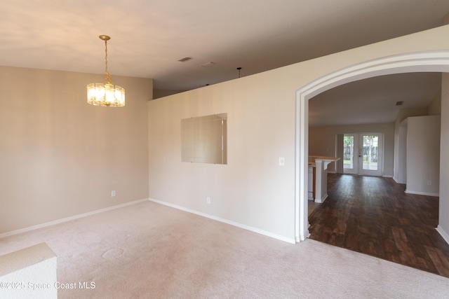 466 Olney St, Palm Bay, FL 32908 - spare room with arched walkways, an inviting chandelier, baseboards, carpet flooring, and visible vents