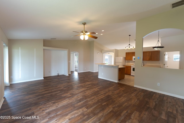466 Olney St, Palm Bay, FL 32908 - unfurnished living room featuring vaulted ceiling, visible vents, arched walkways, and dark wood-type flooring