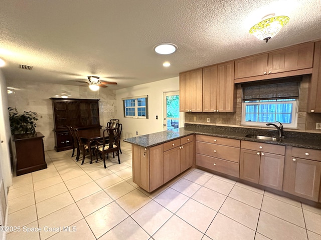 304 Emerald Pl E, Indian Harbour Beach, FL 32937 - kitchen featuring a textured ceiling, a peninsula, ceiling fan, light tile patterned flooring, and dark stone counters