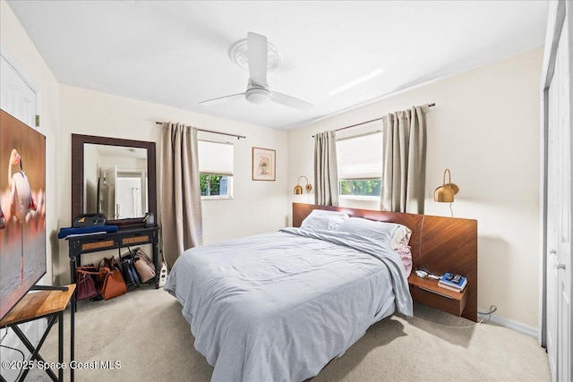 bedroom with light carpet, ceiling fan, and multiple windows
