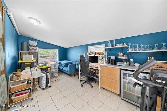 office area with vaulted ceiling and light tile patterned flooring