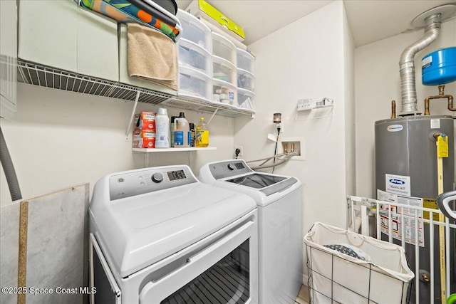 laundry area featuring water heater, washer and dryer, and laundry area