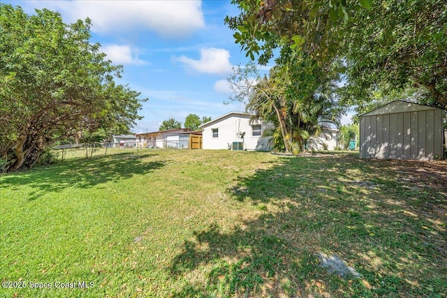view of yard featuring an outdoor structure, a storage unit, and fence
