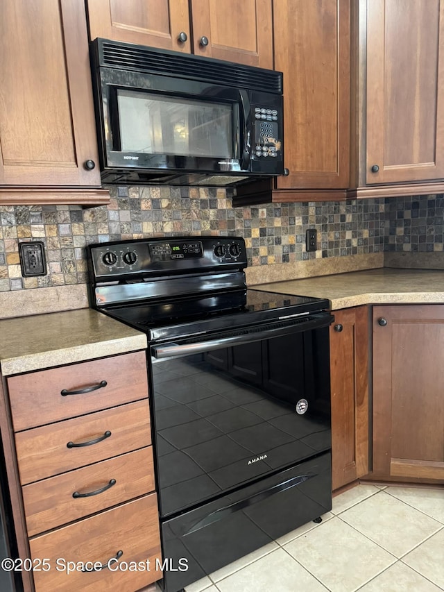kitchen with black appliances, light tile patterned flooring, decorative backsplash, and light countertops
