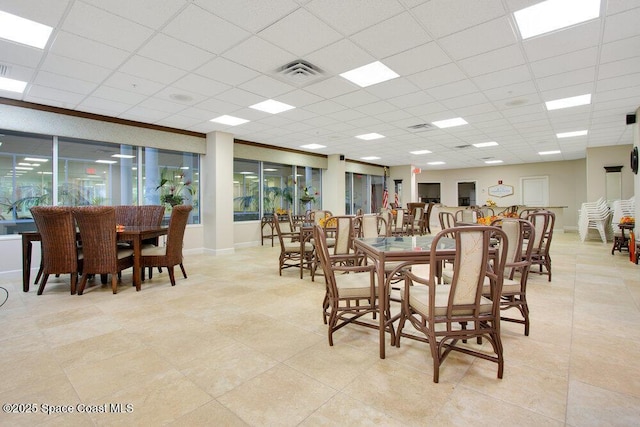 dining area featuring light tile patterned flooring, visible vents, and a paneled ceiling