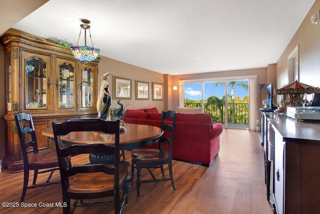 dining space featuring a textured ceiling and wood finished floors