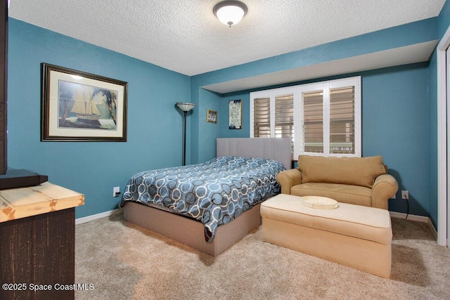 carpeted bedroom featuring a textured ceiling and baseboards