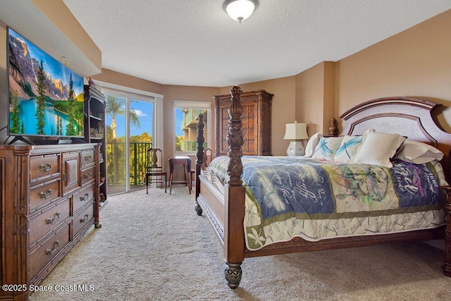 carpeted bedroom featuring access to outside and a textured ceiling