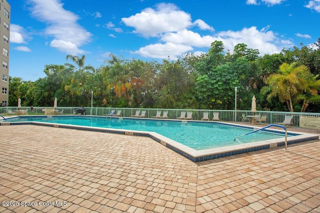 pool featuring fence and a patio area