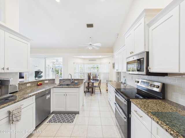 787 Carnation Dr, Sebastian, FL 32958 - kitchen with a peninsula, white cabinetry, a ceiling fan, and stainless steel appliances