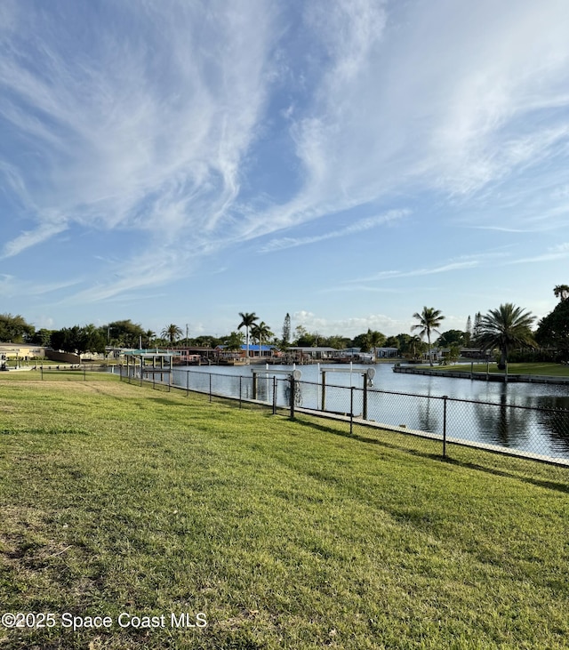 view of yard with fence and a water view
