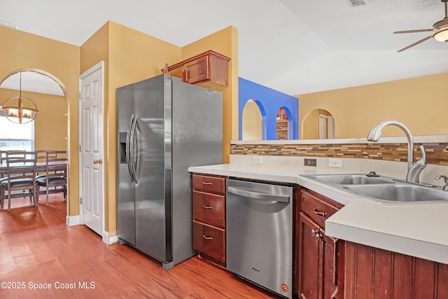 kitchen featuring a ceiling fan, a sink, backsplash, and appliances with stainless steel finishes