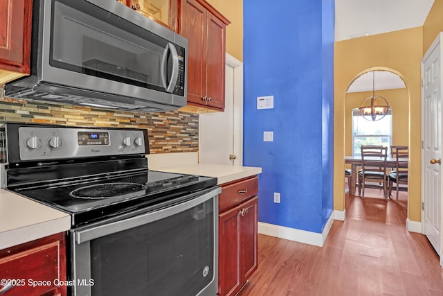kitchen with light countertops, tasteful backsplash, appliances with stainless steel finishes, and baseboards