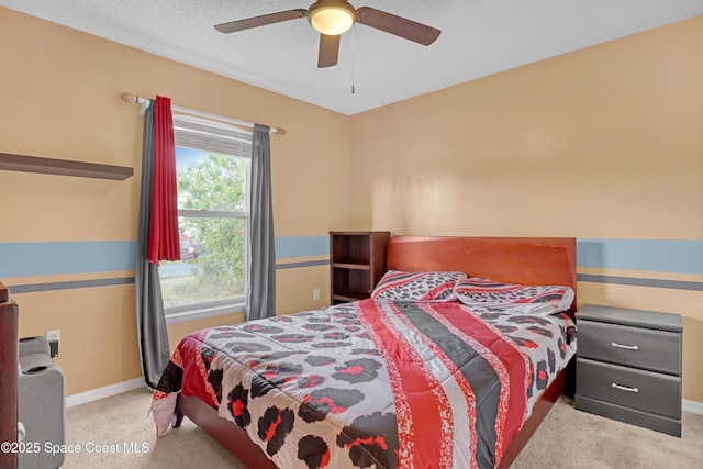 carpeted bedroom with a ceiling fan and baseboards