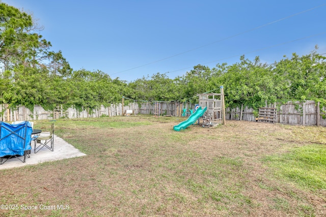 view of yard with a patio area, a fenced backyard, and a playground