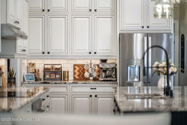 3592 S Park Ave, Titusville, FL 32780 - kitchen with stainless steel fridge, white cabinets, and backsplash