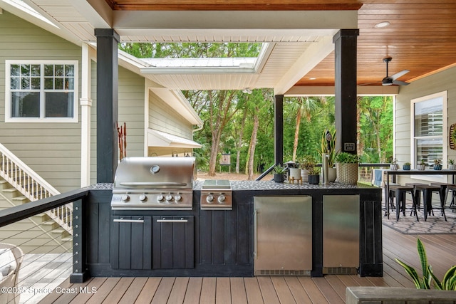 3592 S Park Ave, Titusville, FL 32780 - wooden terrace with area for grilling, exterior kitchen, a ceiling fan, and stairs