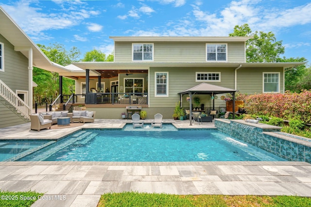 3592 S Park Ave, Titusville, FL 32780 - back of house with stairs, outdoor lounge area, a gazebo, a ceiling fan, and a patio area