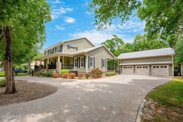 3592 S Park Ave, Titusville, FL 32780 - view of front of house with curved driveway, a porch, an outbuilding, and a garage
