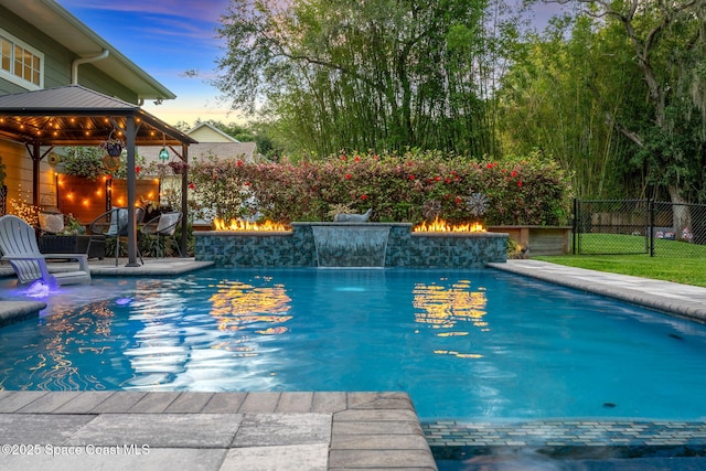 3592 S Park Ave, Titusville, FL 32780 - view of swimming pool featuring a gazebo, fence, a fire pit, a jacuzzi, and a patio area
