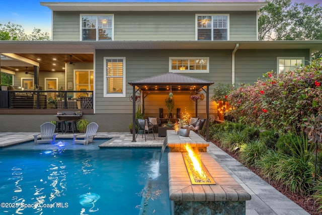 3592 S Park Ave, Titusville, FL 32780 - back of house with a gazebo, an outdoor pool, a patio, an outdoor living space with a fire pit, and ceiling fan