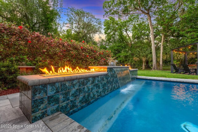 3592 S Park Ave, Titusville, FL 32780 - pool at dusk with an outdoor pool, an outdoor fire pit, and fence