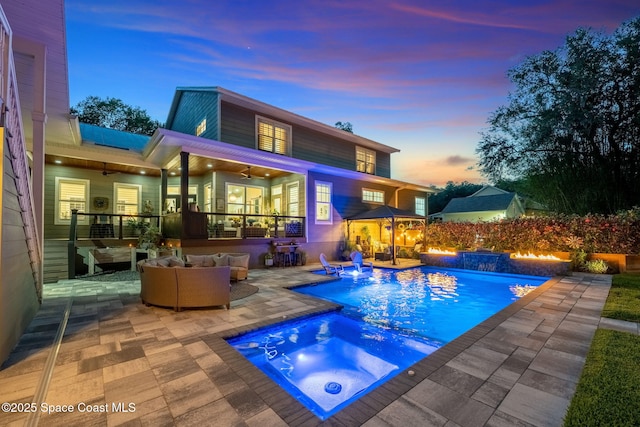 3592 S Park Ave, Titusville, FL 32780 - rear view of property with an in-ground hot tub, a ceiling fan, outdoor lounge area, and a patio