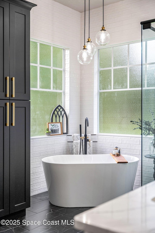 3592 S Park Ave, Titusville, FL 32780 - bathroom with tile walls and a freestanding bath