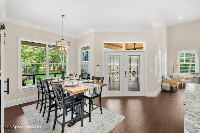 3592 S Park Ave, Titusville, FL 32780 - dining space featuring a chandelier, french doors, healthy amount of natural light, dark wood-style floors, and crown molding