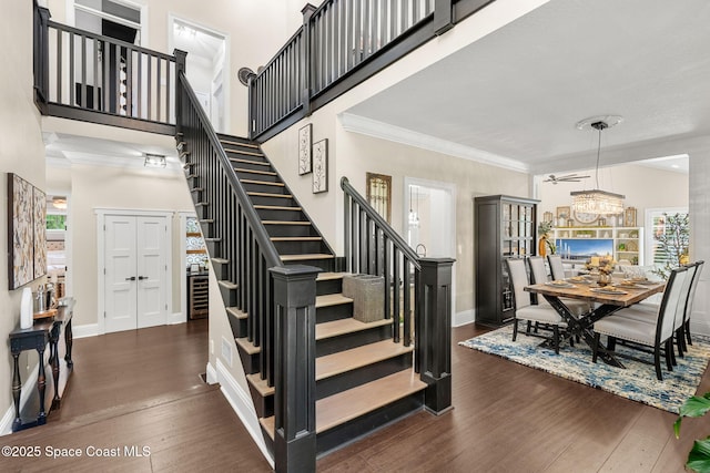 3592 S Park Ave, Titusville, FL 32780 - stairway featuring wood-type flooring, baseboards, ornamental molding, and a chandelier