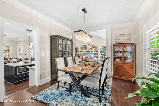 3592 S Park Ave, Titusville, FL 32780 - dining area with baseboards, a chandelier, healthy amount of natural light, dark wood-type flooring, and ornamental molding