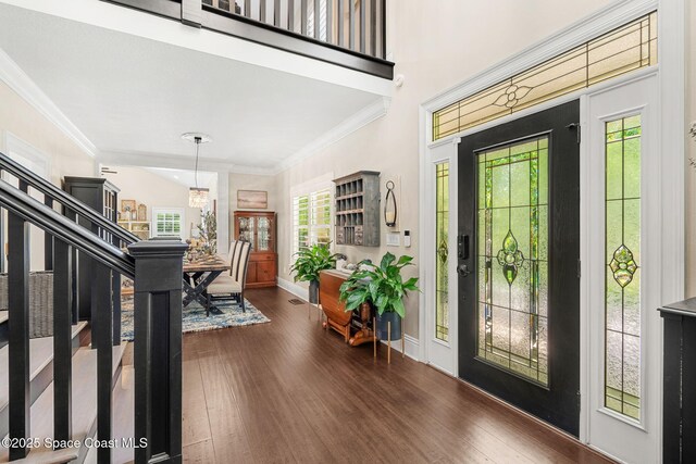 3592 S Park Ave, Titusville, FL 32780 - foyer entrance with dark wood-style flooring, a chandelier, ornamental molding, and baseboards