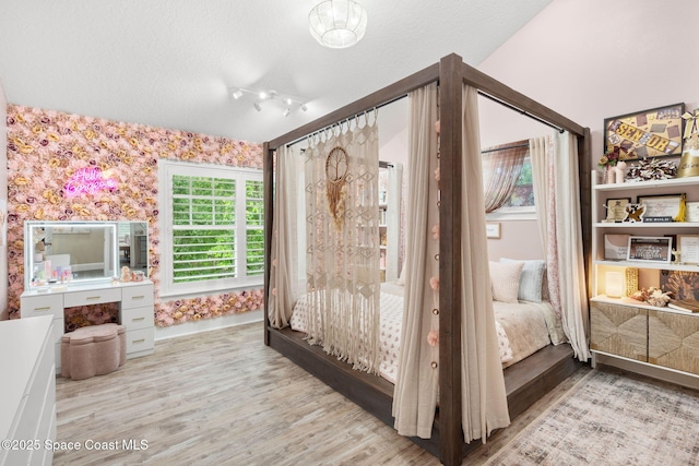 3592 S Park Ave, Titusville, FL 32780 - bedroom with wood finished floors, baseboards, a textured ceiling, and wallpapered walls