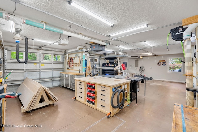 3592 S Park Ave, Titusville, FL 32780 - garage featuring a workshop area, a garage door opener, and baseboards