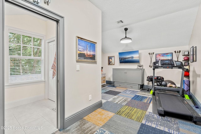 3592 S Park Ave, Titusville, FL 32780 - workout room with baseboards, vaulted ceiling, and tile patterned floors