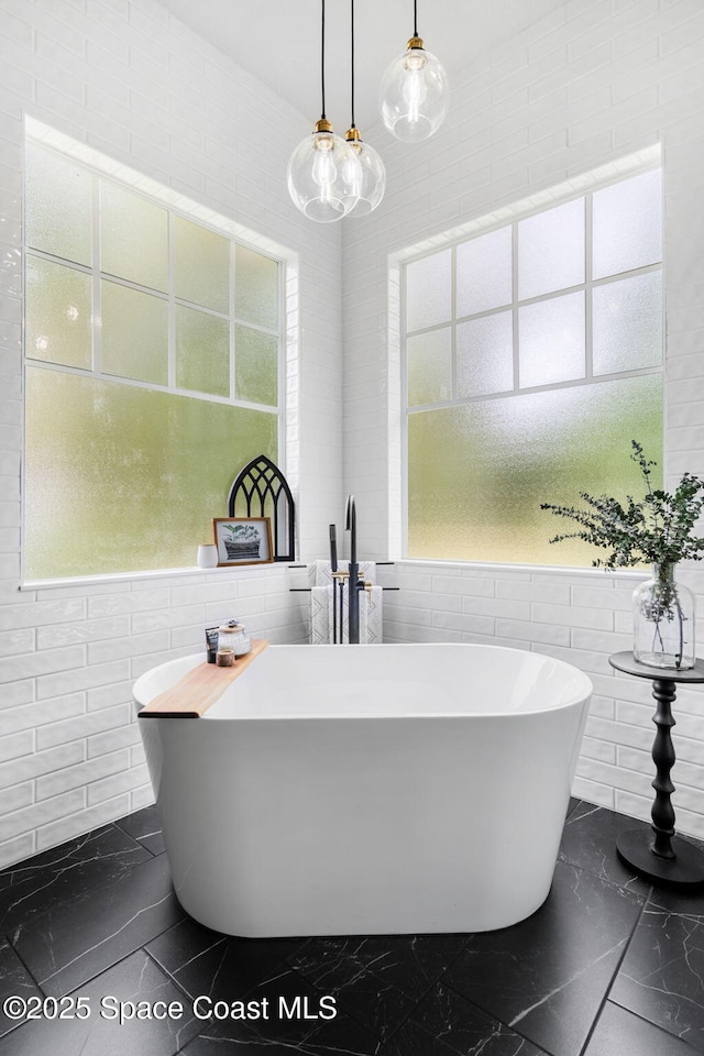 3592 S Park Ave, Titusville, FL 32780 - bathroom featuring tile walls, a soaking tub, and marble finish flooring
