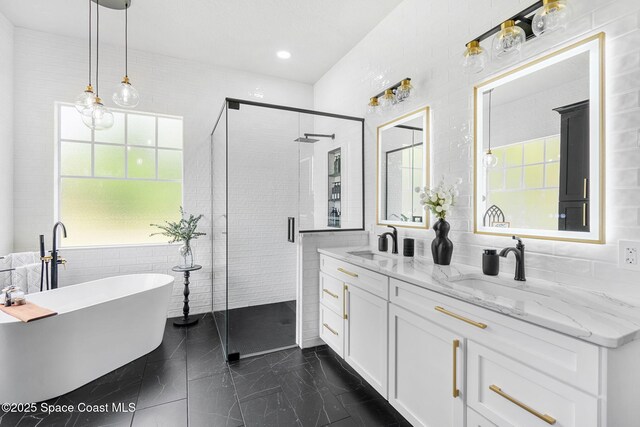 3592 S Park Ave, Titusville, FL 32780 - full bathroom with plenty of natural light, a shower stall, a freestanding tub, marble finish floors, and tile walls