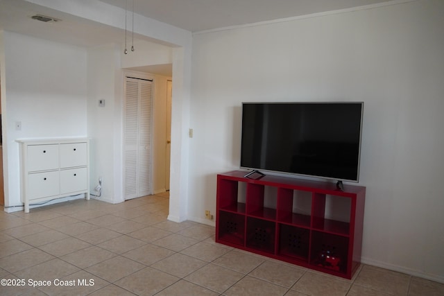 unfurnished living room featuring light tile patterned floors, visible vents, and baseboards