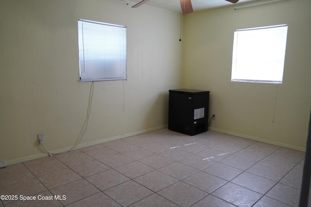 spare room with light tile patterned floors and a ceiling fan