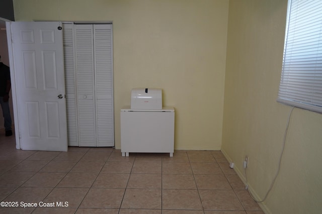 washroom featuring light tile patterned flooring and baseboards