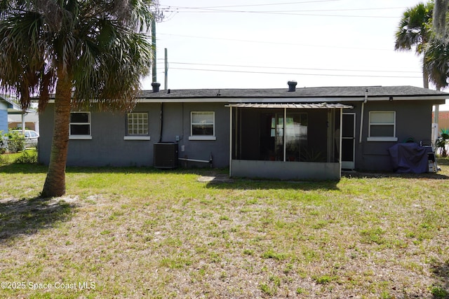 back of house featuring stucco siding, cooling unit, a yard, and a sunroom