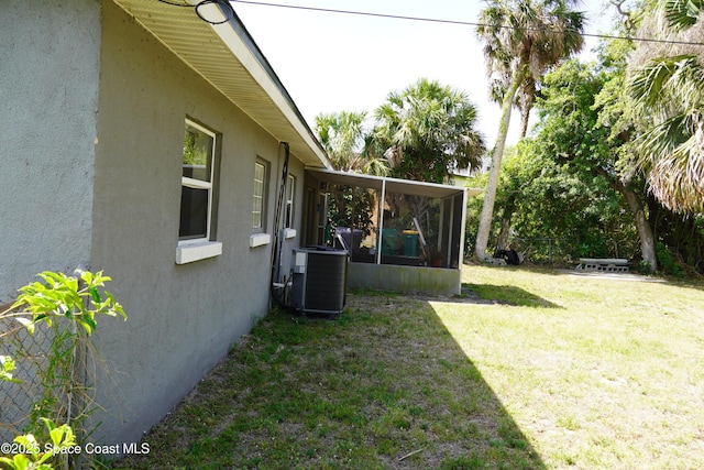 view of yard featuring a sunroom and central air condition unit