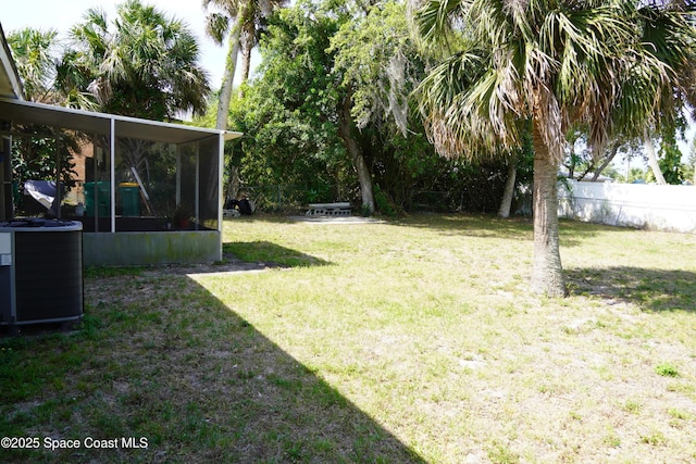 view of yard with a sunroom, central air condition unit, and fence