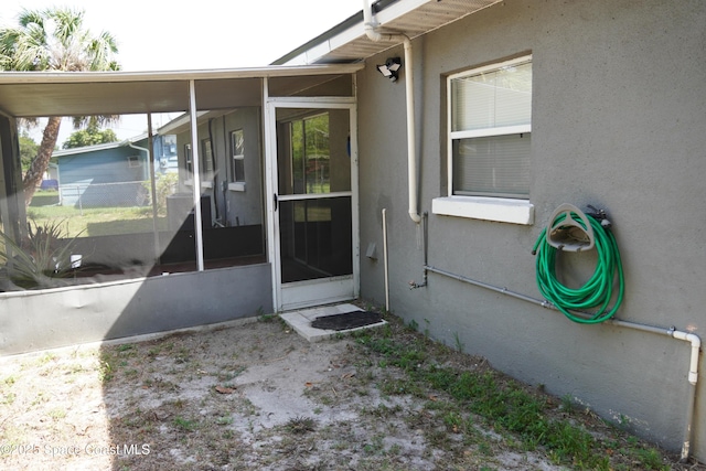 view of exterior entry featuring stucco siding