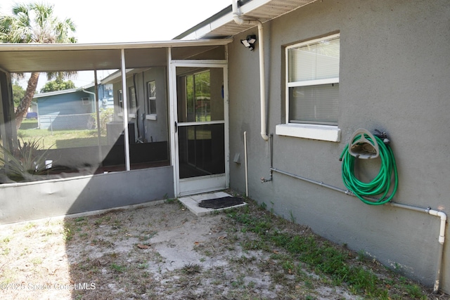 entrance to property featuring stucco siding