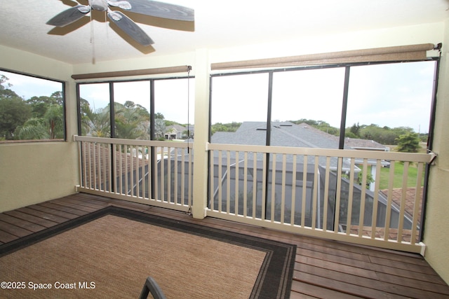 unfurnished sunroom featuring a ceiling fan