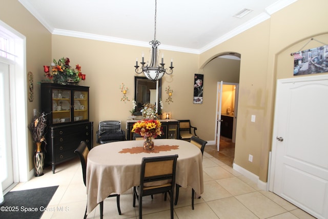 dining room with arched walkways, a chandelier, ornamental molding, light tile patterned floors, and baseboards