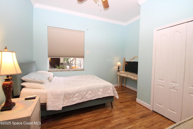 bedroom featuring a closet, ornamental molding, wood finished floors, ceiling fan, and an office area