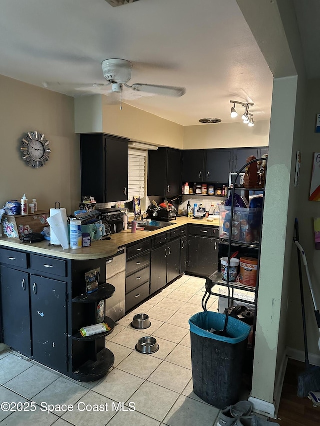 kitchen featuring light tile patterned flooring, dark cabinetry, light countertops, and a ceiling fan