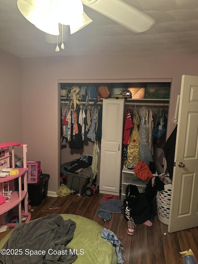 bedroom with wood finished floors and a closet